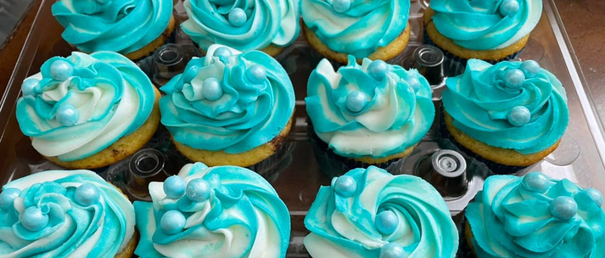 A dozen blue frosted cupcakes