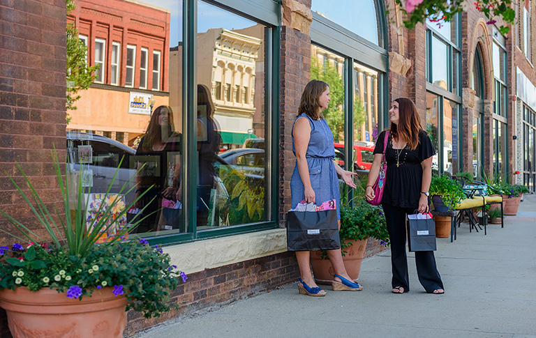 two women chatting outside a store