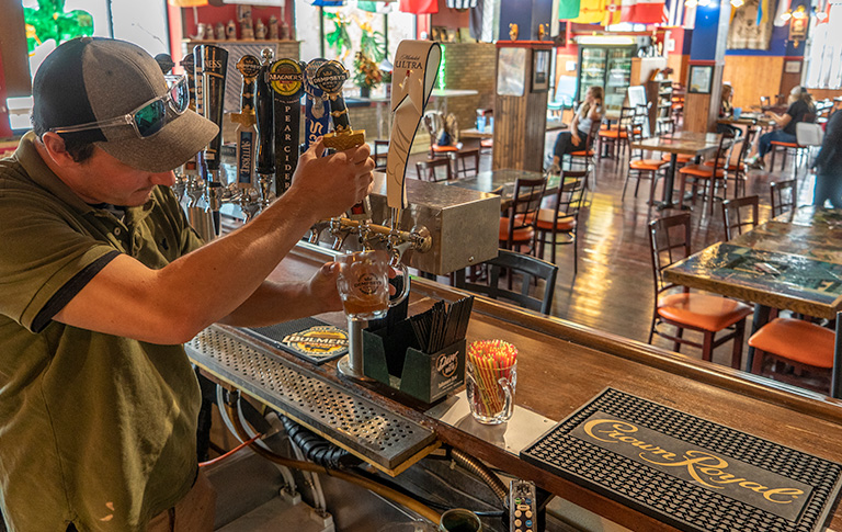 man pulling a beer behind a bar